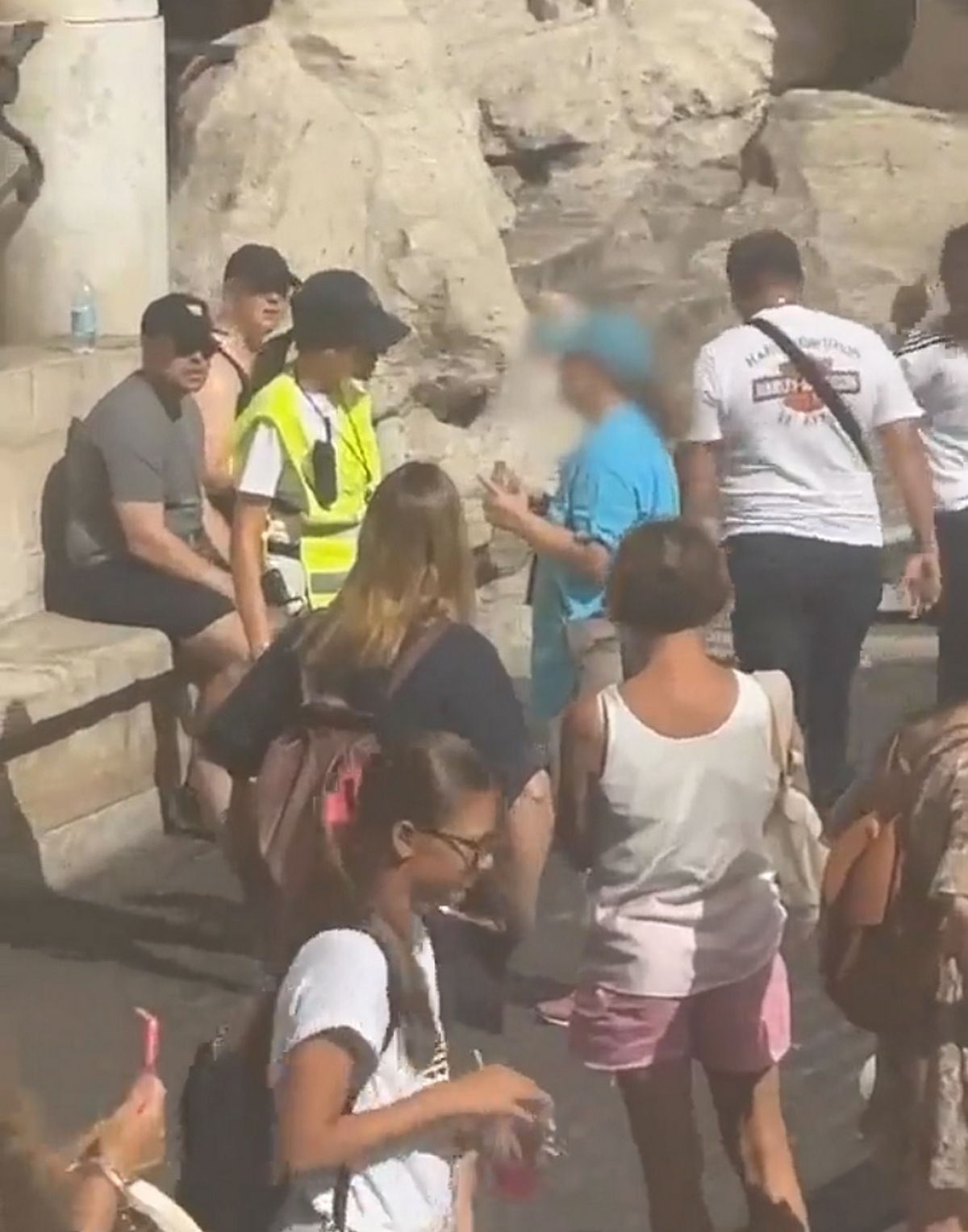 La touriste s'est éloignée de la fontaine avant d'être confrontée à une officière, qui lui a vraisemblablement adressé une sévère réprimande.